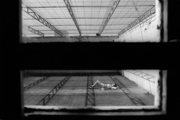 Black and white photograph of a prisonersunbathing.