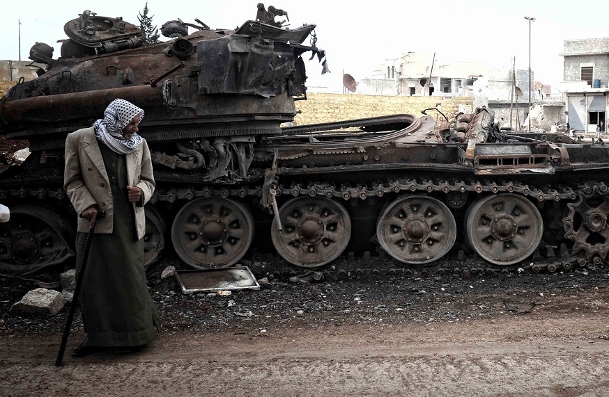 Arabic man next to wreckage of tank