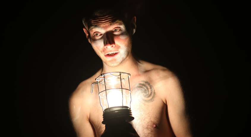 bare chested man holding storm light